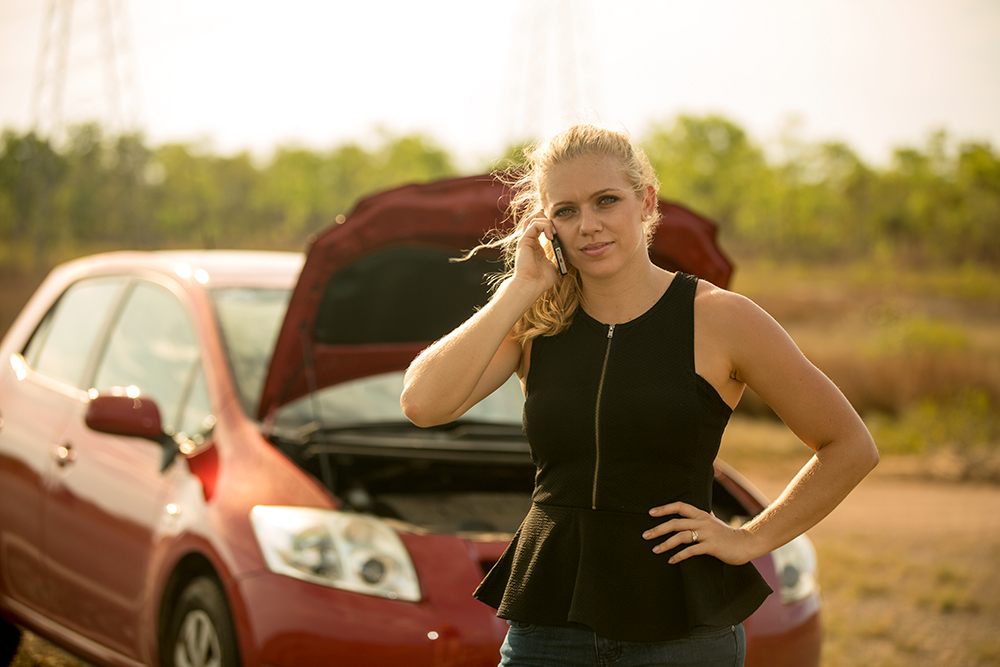 Young woman broken down making a phone call 