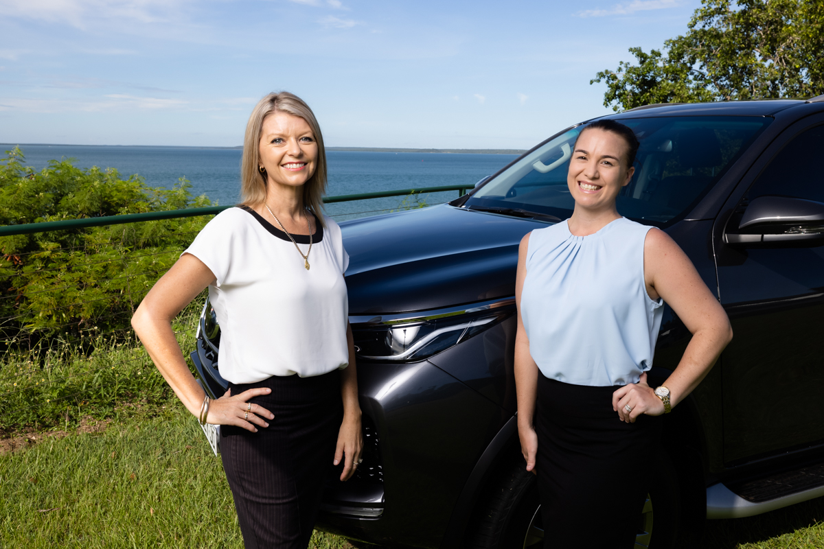 Two women smiling in front of a car on the Esplanade Darwin