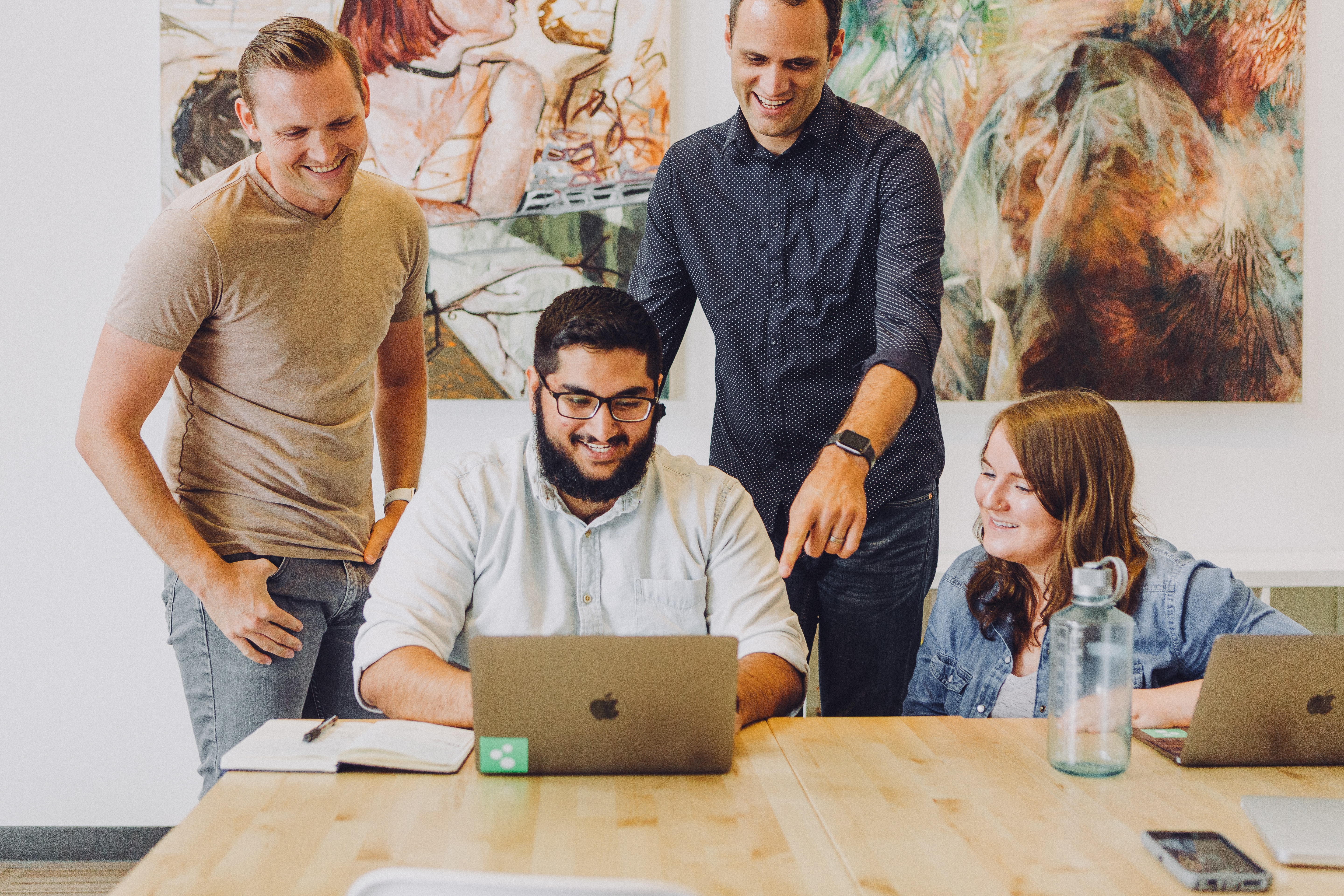 Employees chatting around a computer 