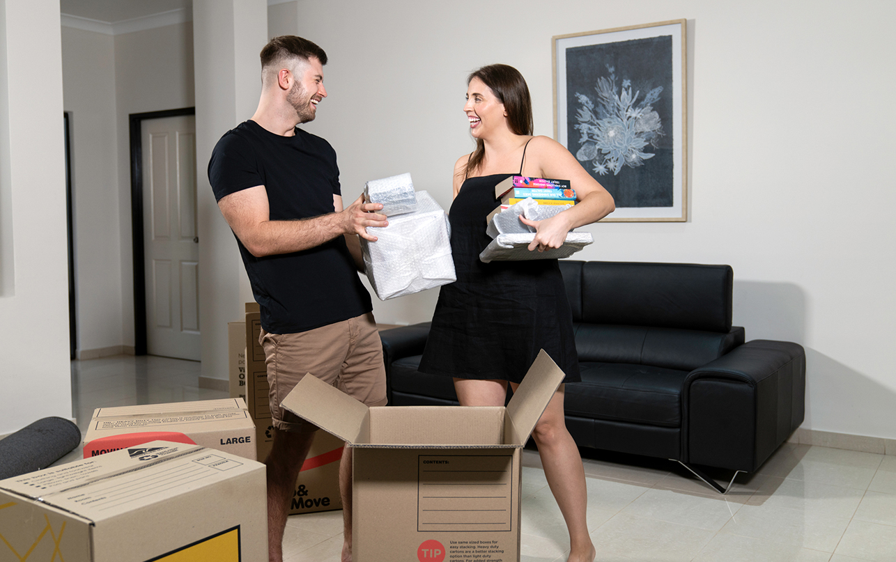 Couple unpacking moving boxes in their new home