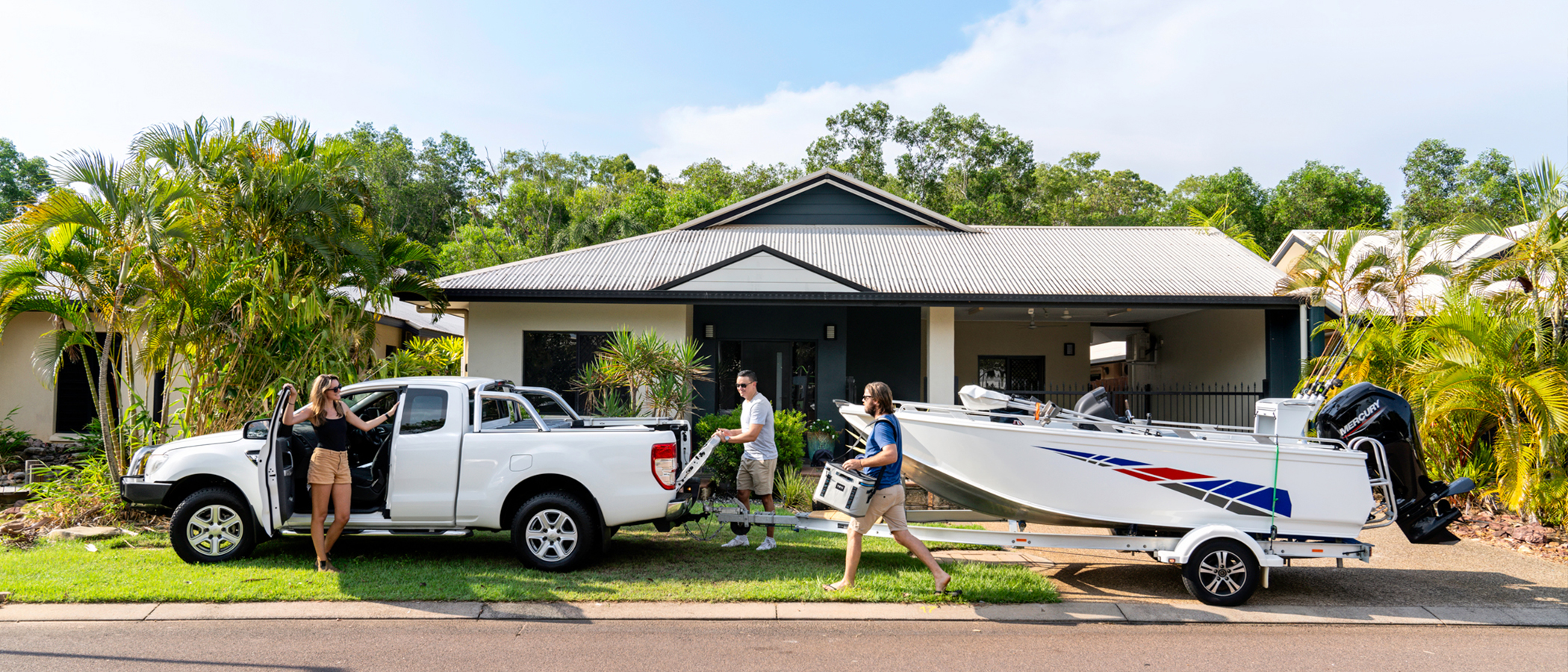 Friends packing the car and boat in front of house