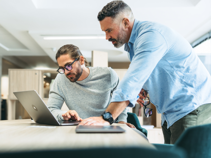 Two men reviewing something on the computer