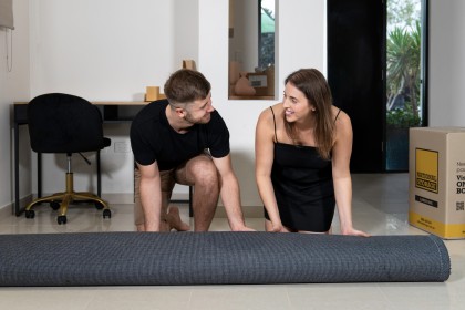 Couple unpacking carpet in their new home