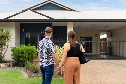 Couple in front of their new home