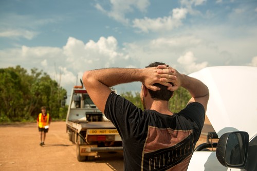 Man car broken down watching tow truck