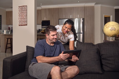 Couple in their house looking at an ipad 