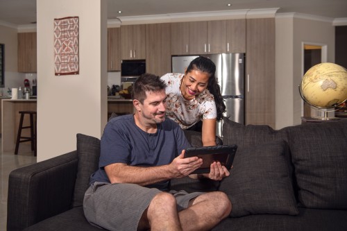 Couple in their house looking at an ipad 