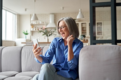 Woman on phone expressing excitement, as if she just won something.