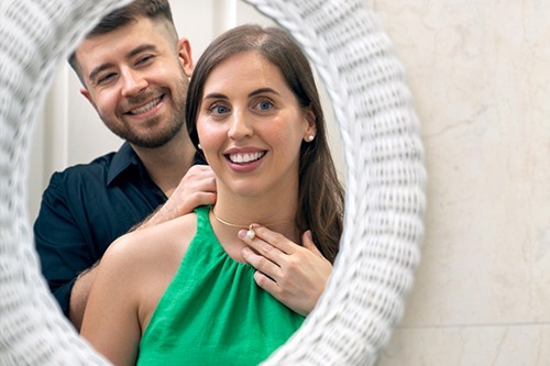 Man helping a woman to put on her necklace