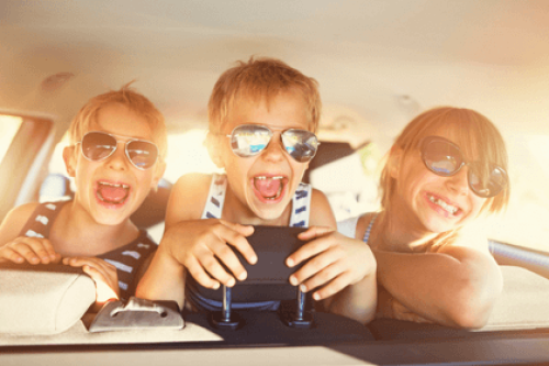 Kids laughing in the back seat of a car