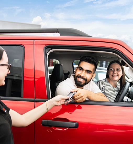 Couple buying a new car at a car dealership.